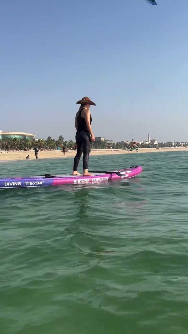 Stand-up paddleboarder on open water near the Dubai skyline